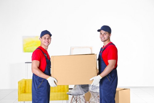 Professional movers carrying furniture through a Chiswick property